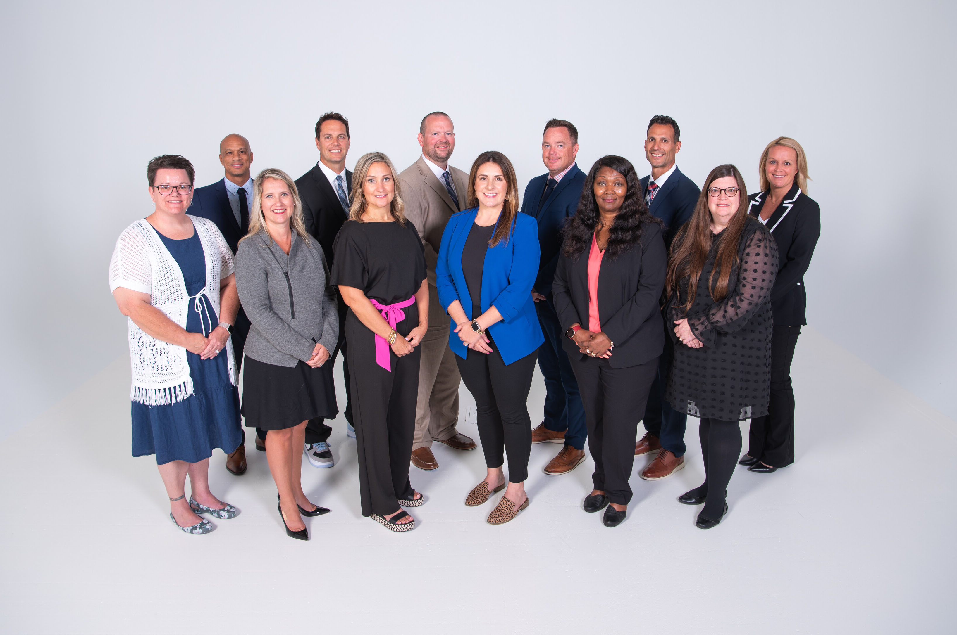 group shot of people standing in front of light background